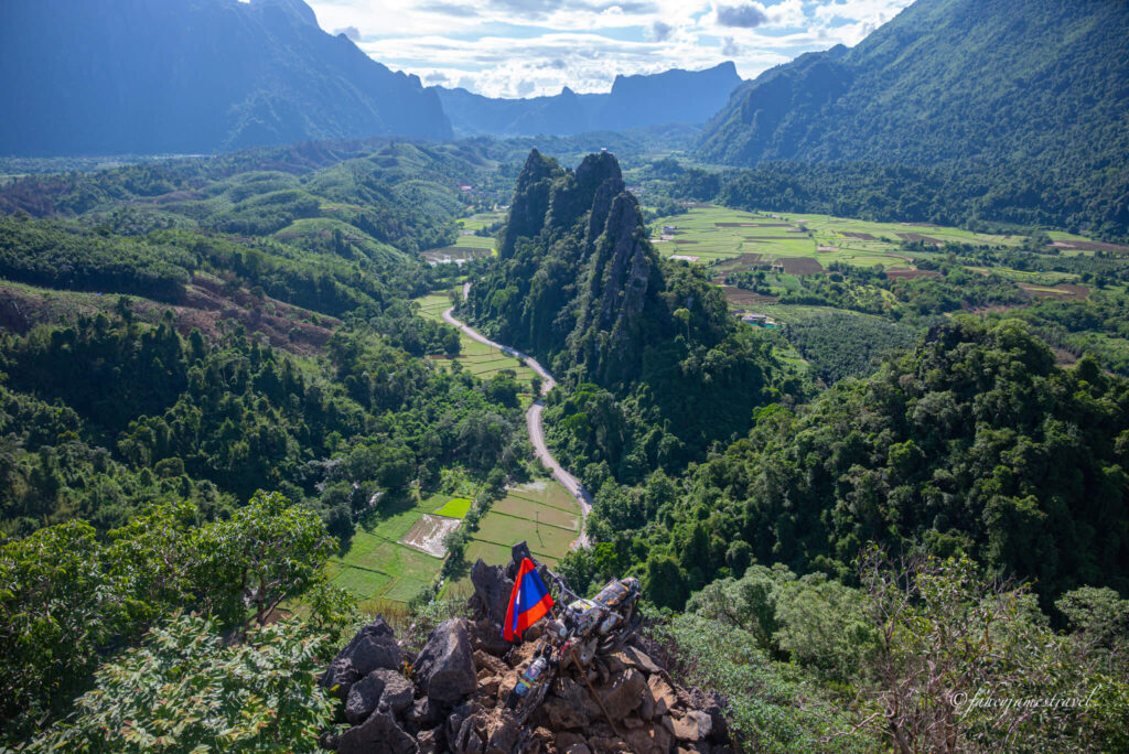 Nam Xay viewpoint shows a view over the rice fields in Vang vieng. You can see the motorbike and the Las flag attached to it at the bottom of the image