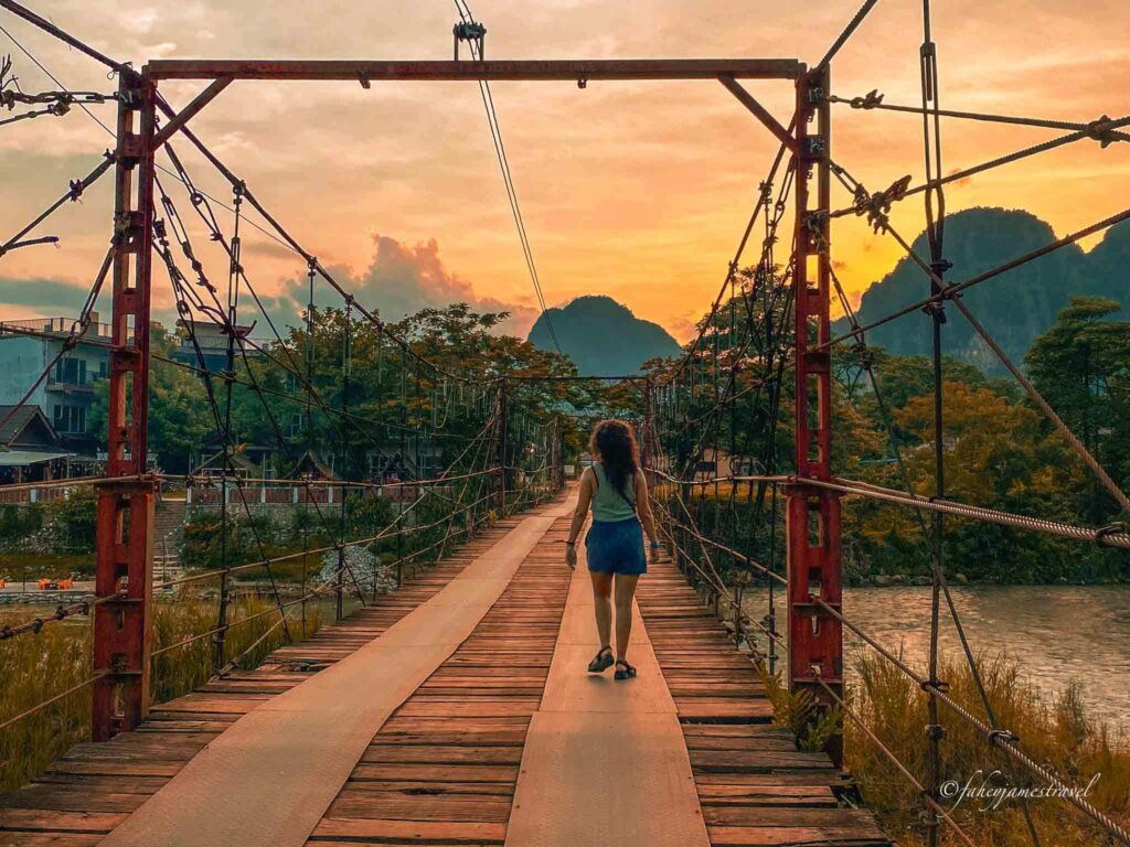 gauda walsk across a bridge in vang vieng