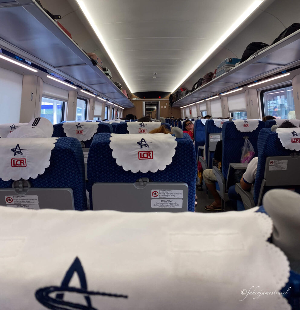 The Laos to China train shows many people sitting and sleeping as we move through Laos