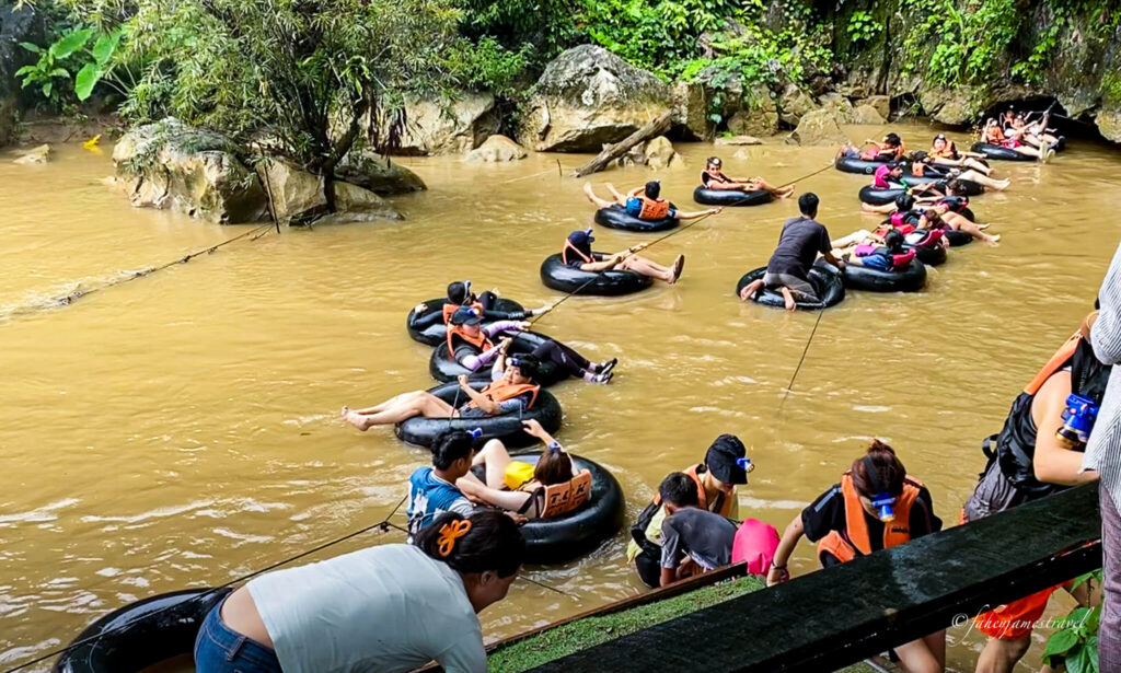 many people are tubing out from a cave which was part of the blue lagoons tour
