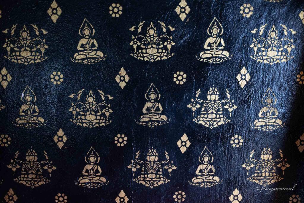 Temples In Luang Prabang shows black mural on the wall