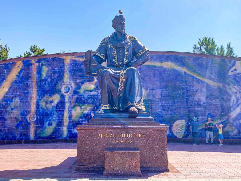 Ulugh Beg statue outside the Observatory with blue wall and sky, one of the top things to do in samarkand