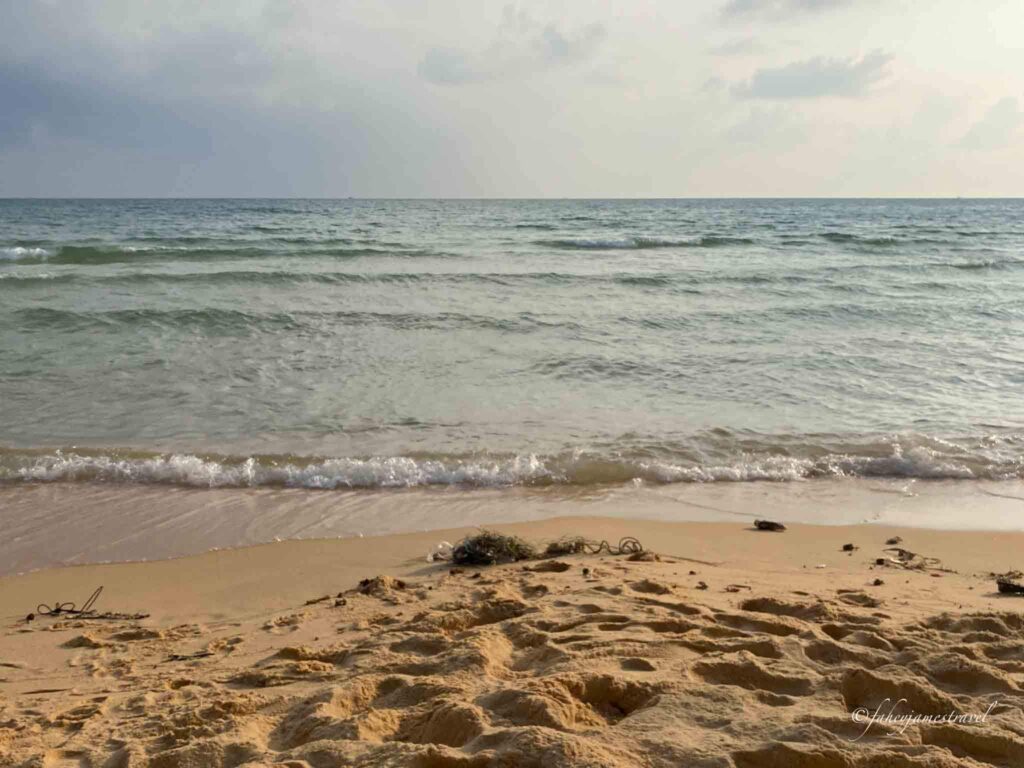 lazy beach koh rong samloem is pictured with sand and water with clouds 
