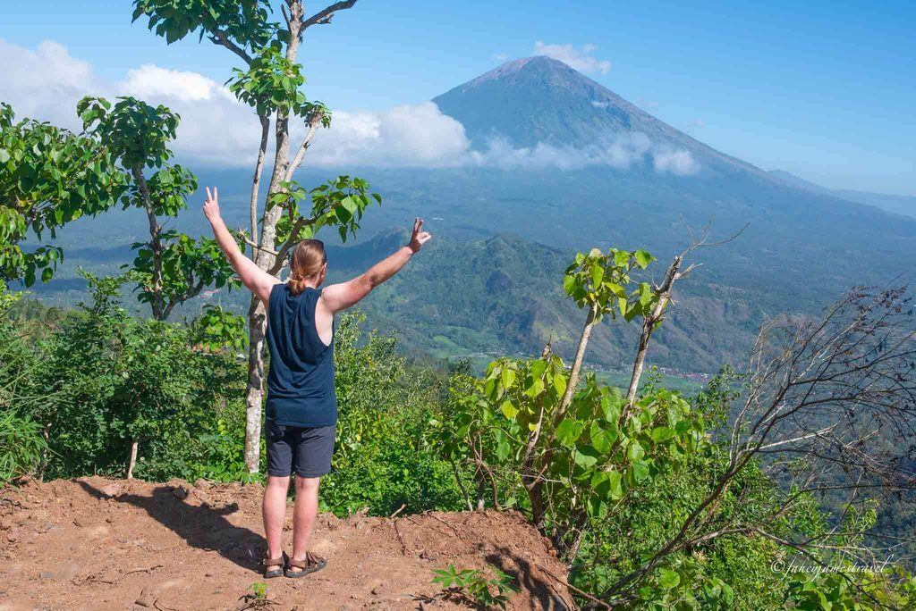 james stands with arms our wide looking at mount agung from lahangan sweet