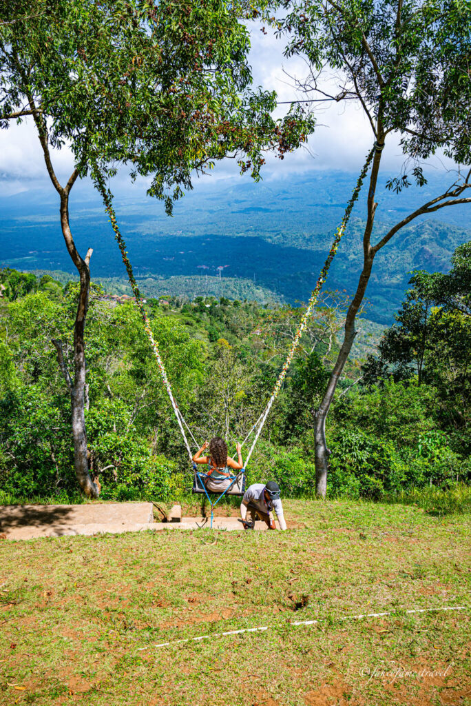 guada swings on one of lahangan sweets big swings. the area is full of lush greenery 