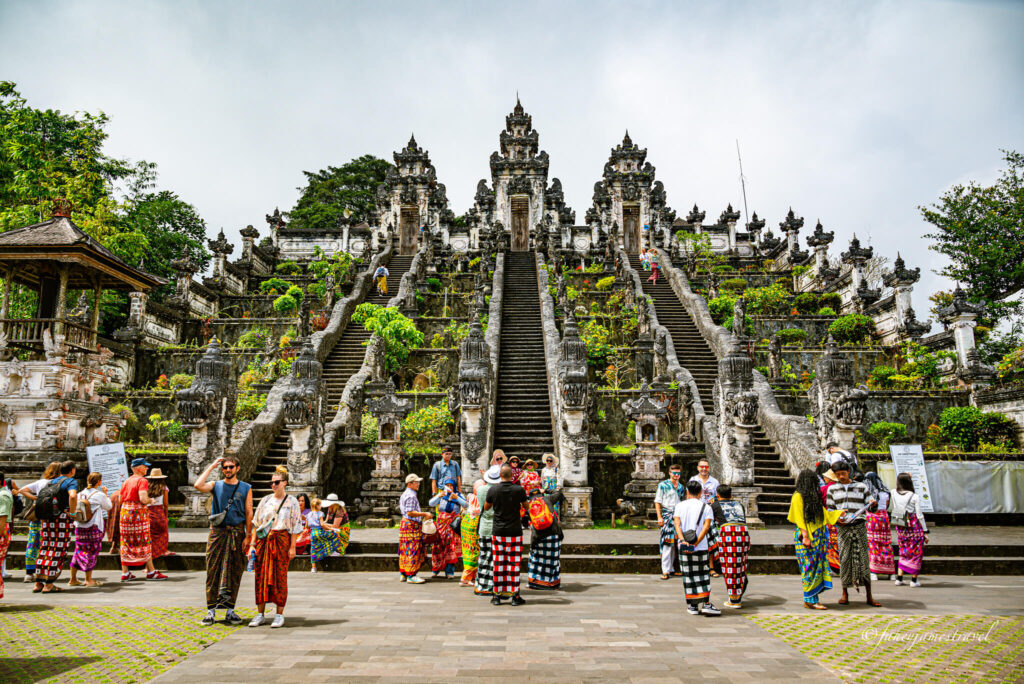 many people stand beside lempuyang temple taking photos on the stairs 