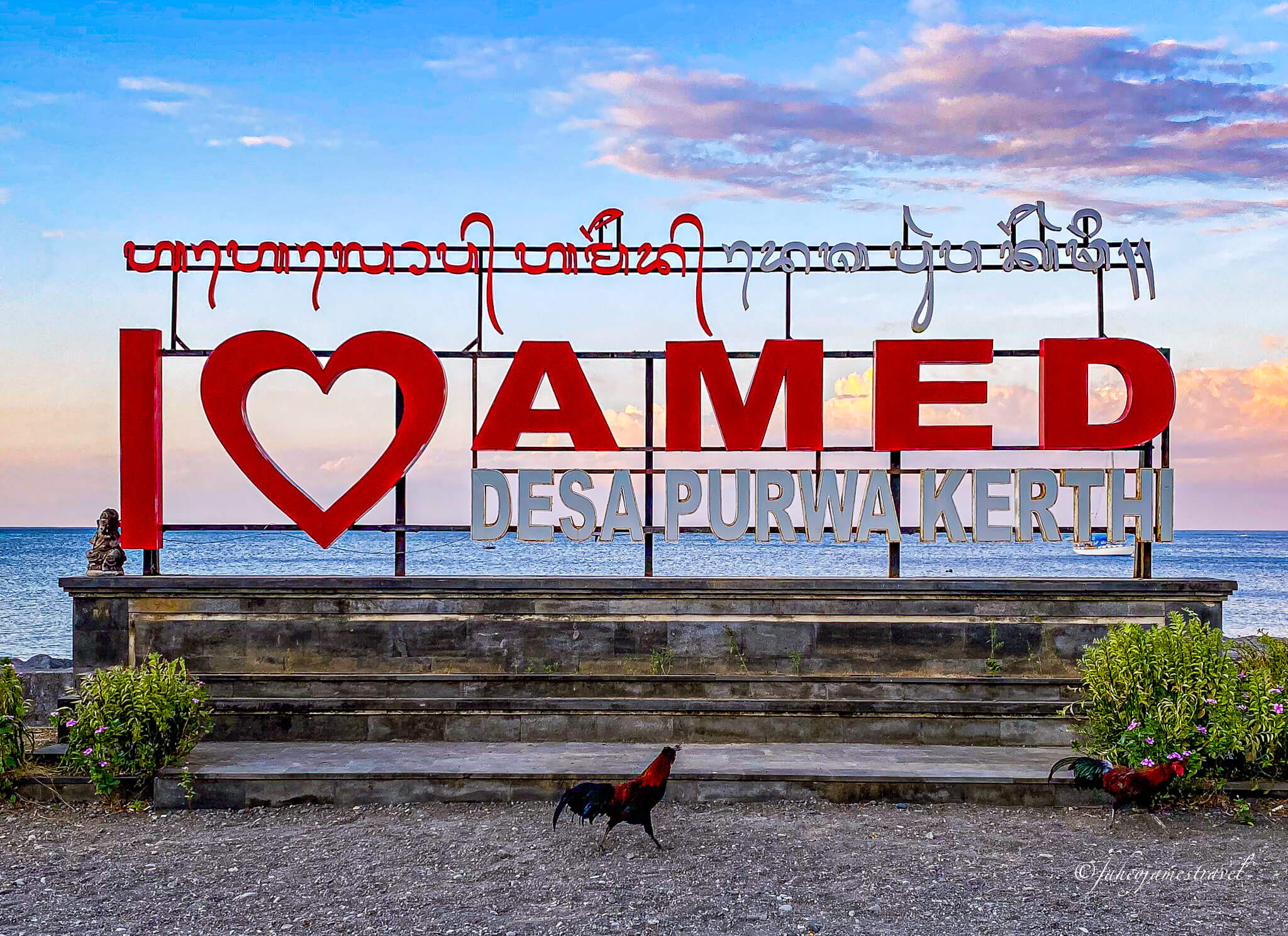 a red signpost that says I heart amed. there are two red chickens in the bottom of the image