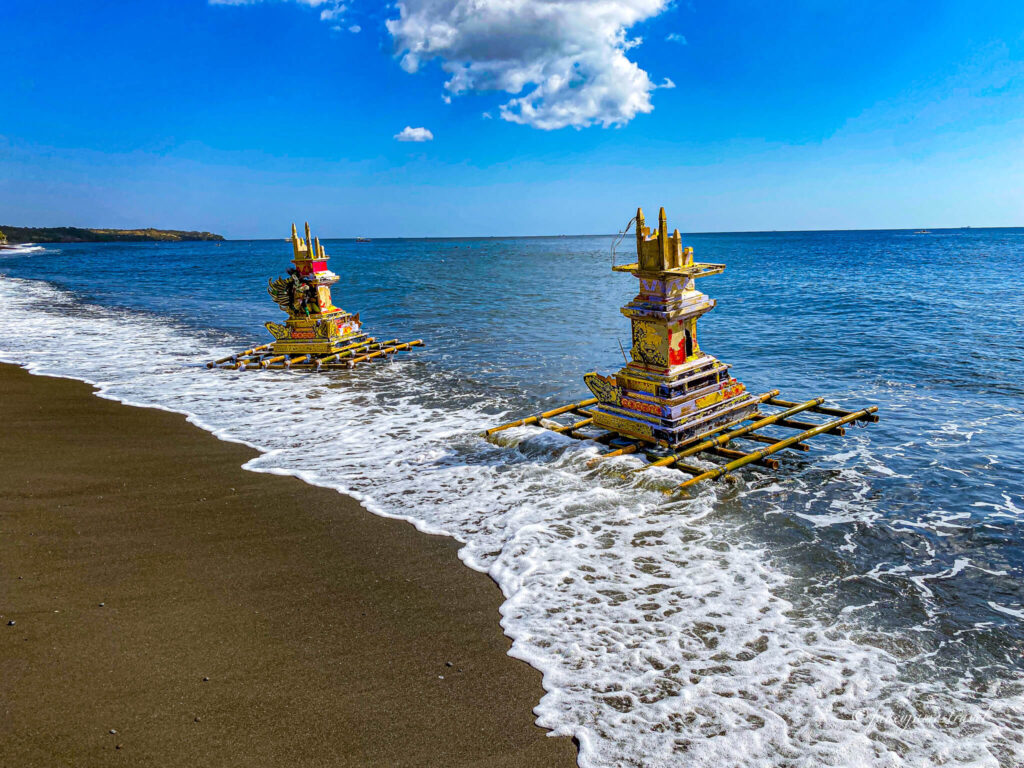 some ceremonial water floats are in the shore where the waves are barely crashing