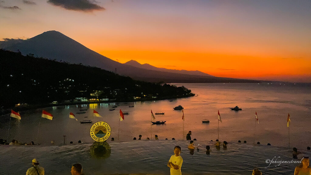 sun set at amed point bali. there is an affinity pool in the foreground and the sky is yellow and nice