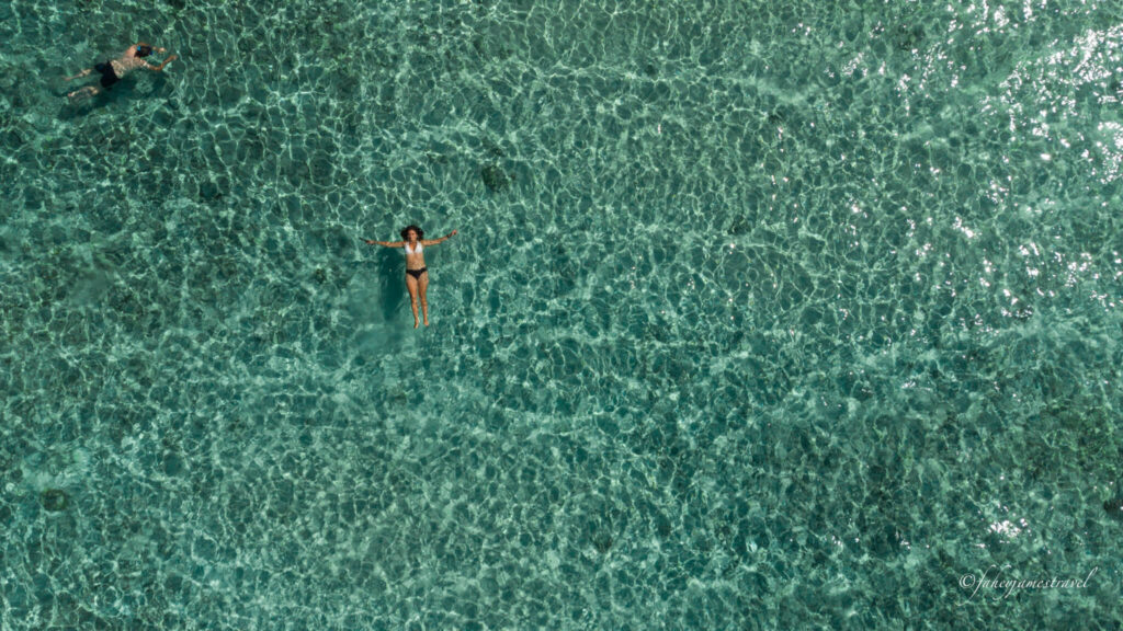guada floats in the water on gili trawnagan in the clearest blue water