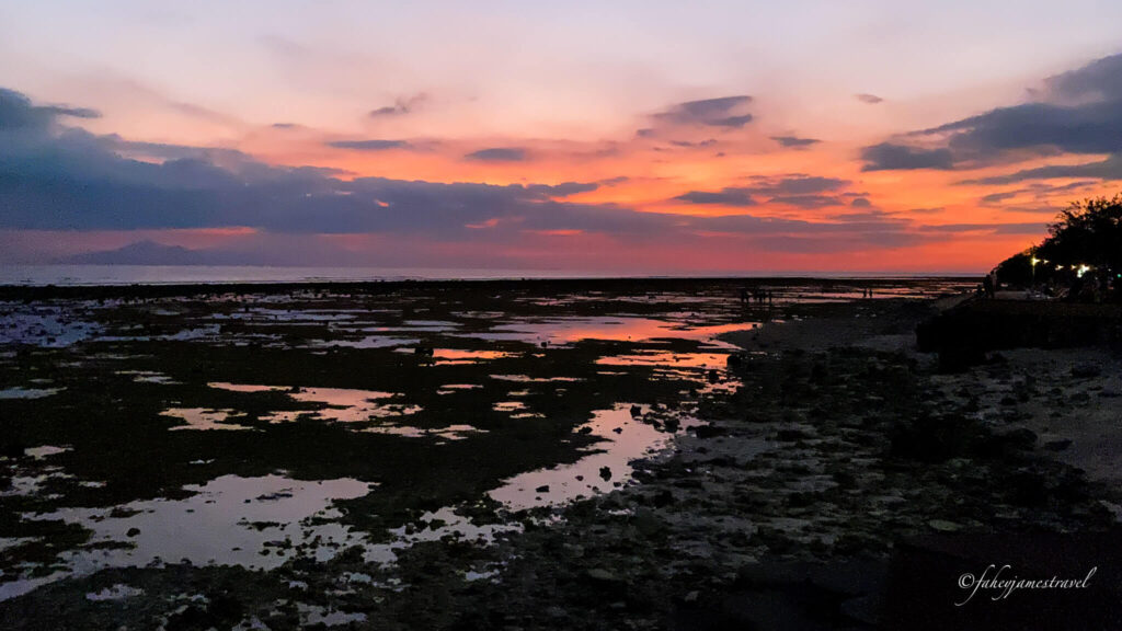 sunset beach gili trawangan has a sky that is pink and orange and some water pools int he foreground   sunset point gili trawangan