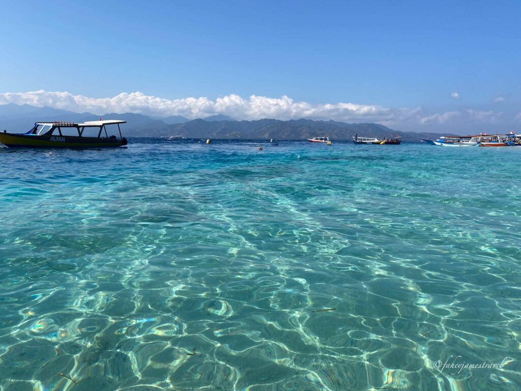 amazin clear water can be found between gili t and gili meno. you can see one boat to the left. Where To Stay In Gili Trawangan
