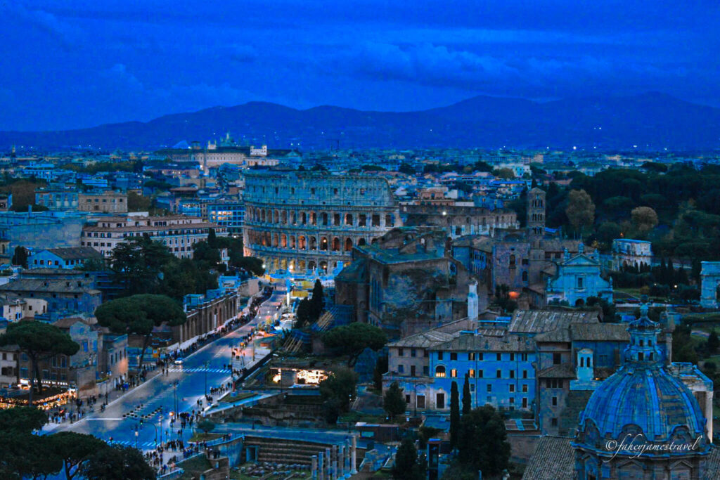shot of the colosseum romes most important site from the top of the alter of the fatherland. night is falling and its getting dark 