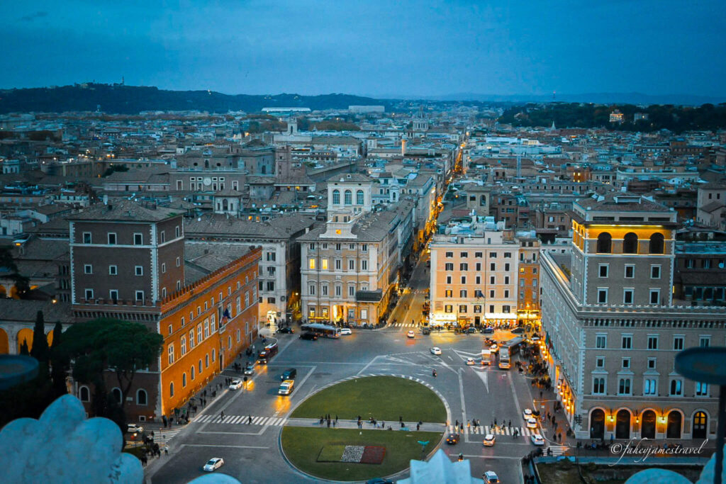 view from the terrace on the alter of the fatherland looking down as the sunsets and the sky changes colour to dark blue 