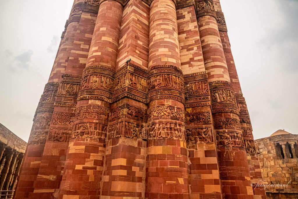Close-up shot of the inscription on the Qutub Minar. It is red sandstone 
