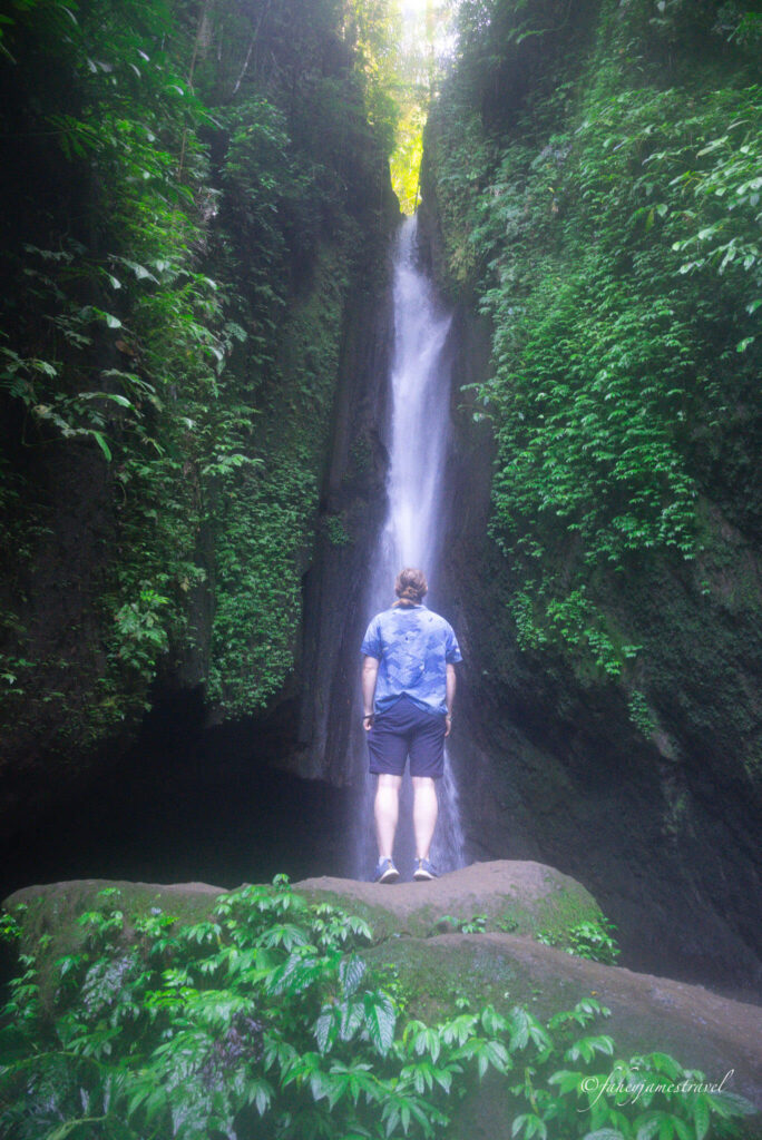 james stands wioth his back to the camera at leke leke waterfall
