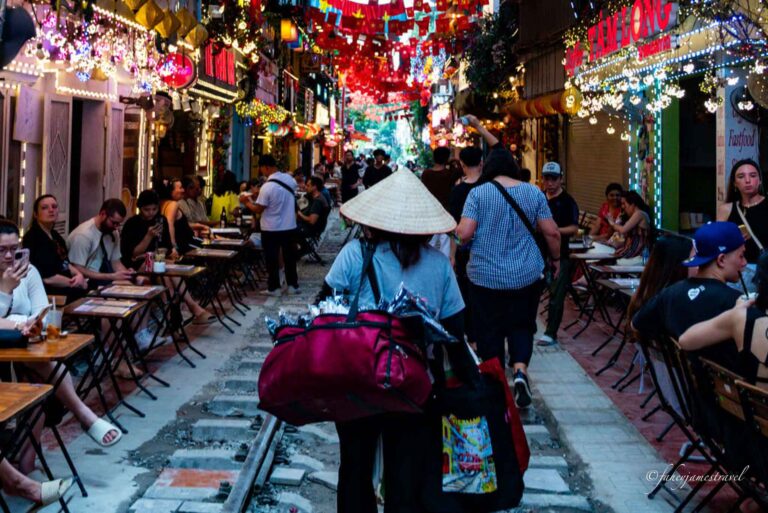 hanoi train street shows a lady walking along the track selling food