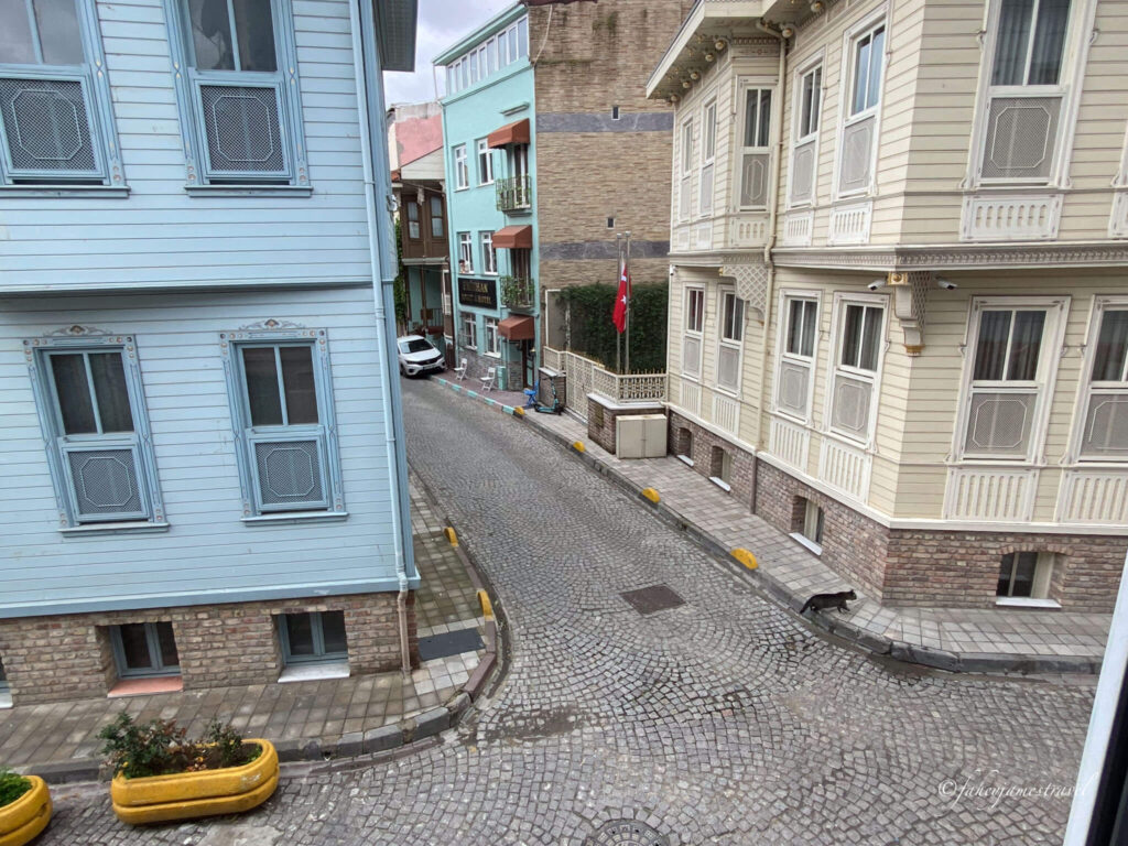 sultahamet is a great place to stay on your first trip in istanbul. cobblestones streets are shown with blue and yellow buildings