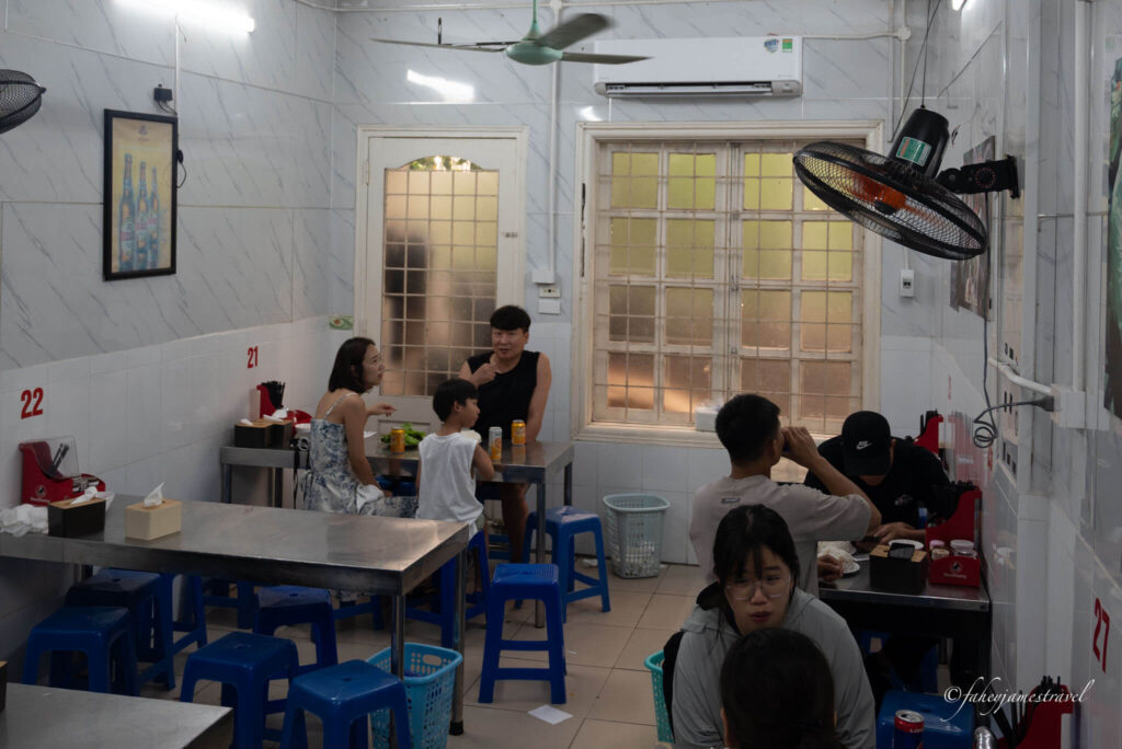 people sit inside Bún Chả Hương Liên - The Obama/Bourdain Restaurant