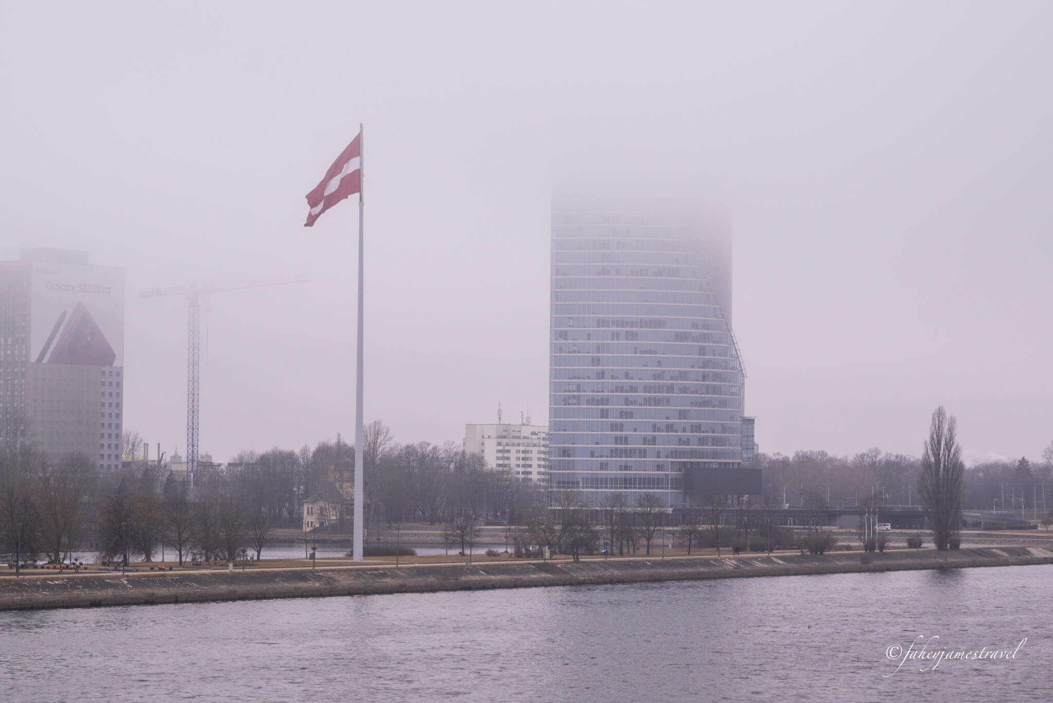 riga in winter shows the latvian flag flying in the mist