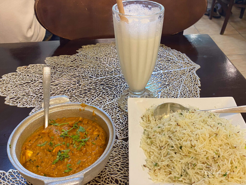 paneer chicken is shown on the table with sweet lassi and rice
