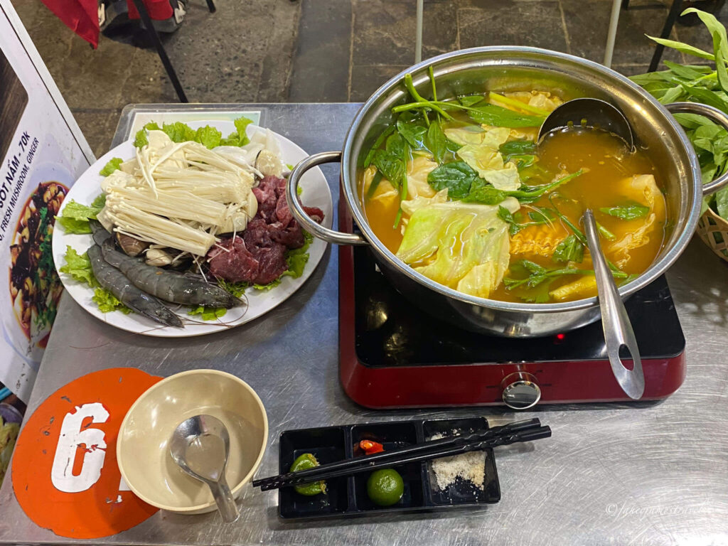 a hot pot is shown befire its cooked at Lẩu Nướng Các Món Nhậu  in the odl quarter