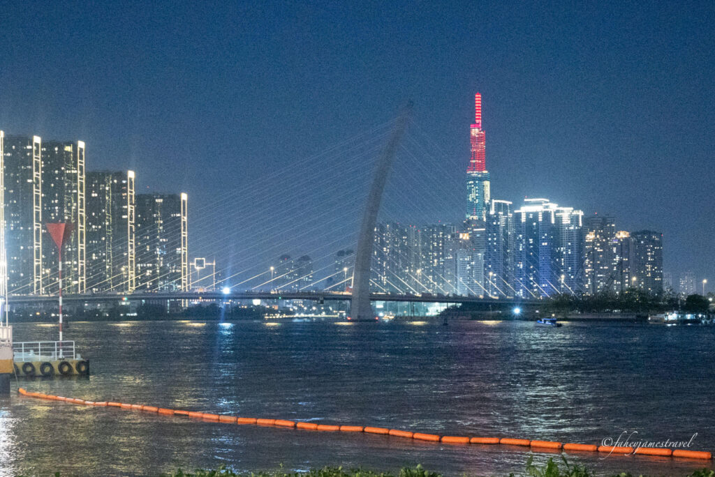 the skyline of ho chi minh city is pictured at night with red and yellow lights. part of the 7 day itinerary for Vietnam 