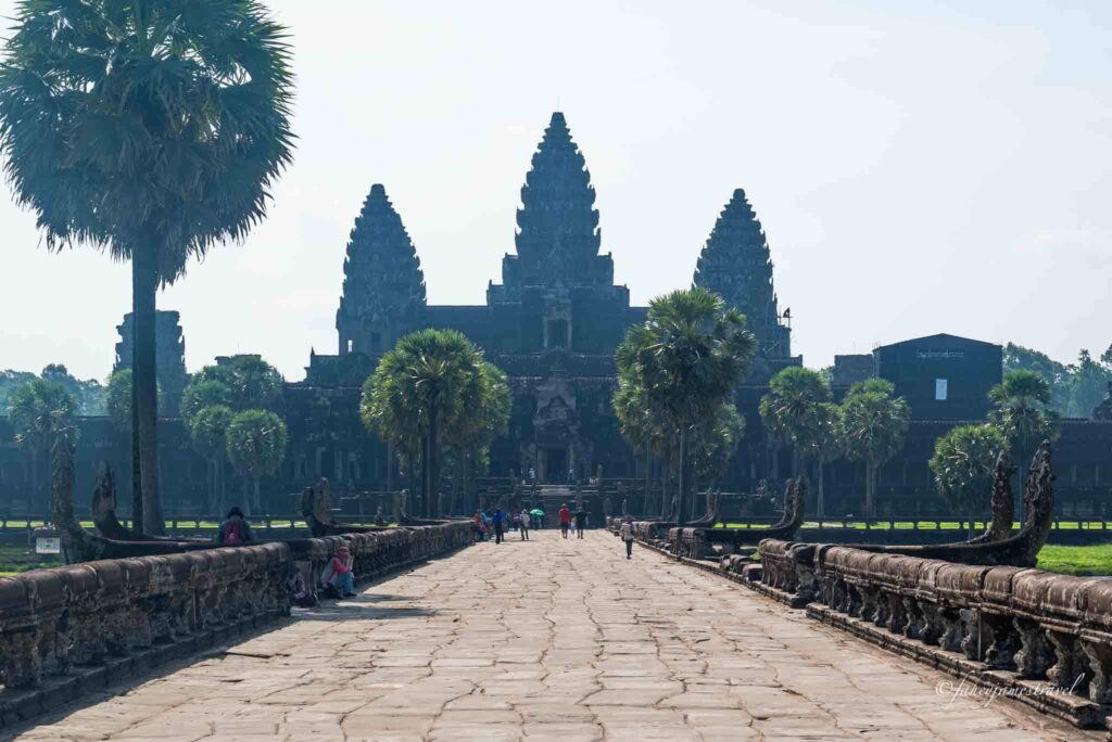 the walkway to angkor wat is pictured and how to visit is simple